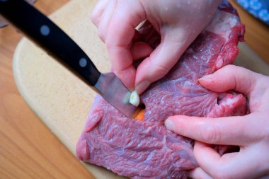 Lezzetli bir yemek hazırlamak için yetenekli eller taze eti ustalıkla keser..