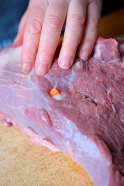 Yetenekli bir el, ahşap bir yüzeyde çiğ eti inceler..