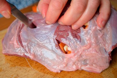 Eller ustalıkla taze et keser, canlı sebze dolgusunu ortaya çıkarır..