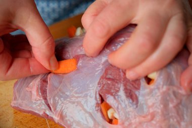 Eller ustalıkla eti sebzelerle, mutfak sanatı ile doldurur..