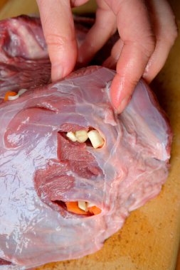 Dikkatlice eti sarımsak ve sebzelerle doldurun..