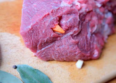 Canlı bir et parçası ahşap bir tahtanın üzerinde duruyor, pişirmeye hazır..