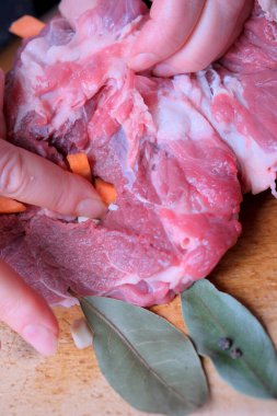 Eller dikkatlice domuzu taze malzemelerle doldurup lezzetli bir yemek yaratıyor..