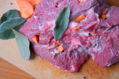 Parlak renkli çiğ et havuç ve otlarla süslenir, pişirilmeye hazır..