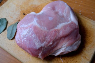 Ahşap bir tahtanın üzerinde domuz pirzolası pişmeye hazır..