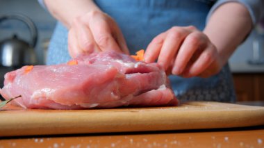 Sıcak bir mutfakta taze sebze ve çiğ domuz eti dikkatlice tatlandırır..