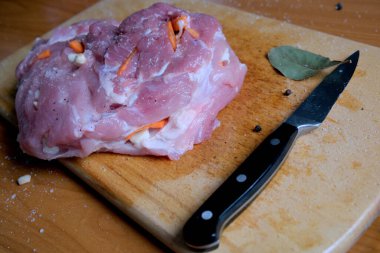 Sulu domuz omzu ahşap bir tahtada duruyor, baharat ve pişirmeye hazır..