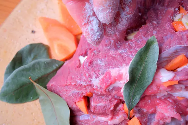 Eller tuzlu, otlarla ve doğranmış havuçlarla çevrili bir et dilimi mevsimi.