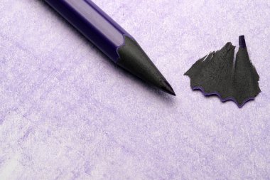 Mor bir kalem lavanta kağıdındaki siyah talaşların yanında oturur, yaratıcılığa ilham verir..