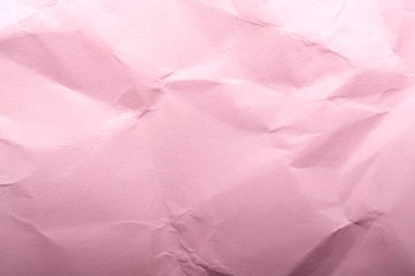 Yumuşak buruşuk pembe kağıt düz yatar, sanatsal ifade ve tasarım davet edilir..