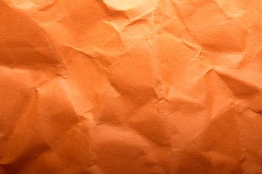 Buruşmuş turuncu kağıt karakterlerle dolu soyut bir tasarım sergiler..