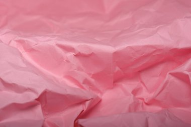 Buruşuk pembe kağıt yaratıcı çalışma alanına hassas bir dokunuş ekler..