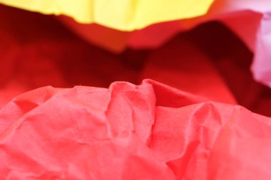 Kırmızı, sarı ve mor renkli kıvrımlı kağıtlar boşluğu neşeyle doldurur..