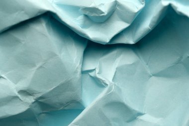 Buruşuk turkuaz kağıt sanatsal ilham için davet edici bir doku sunuyor.