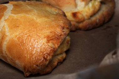 Taze pişmiş altın hamur işleri parşömen üzerinde dinlenir, sıcak bir aromayı davet eder.