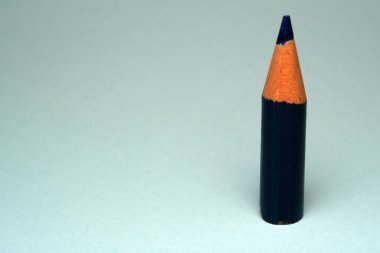 Turuncu uçlu çarpıcı renkli bir kalem arka plana yaslanıyor.