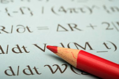 Kırmızı kalem matematik formüllerini vurguluyor, yaratıcılığı ateşliyor.