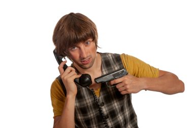 Ekose yelekli genç bir adam, elinde ateşli bir silahla telefonda acil bir şekilde konuşuyor..