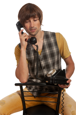 Ekoseli yelek giyen genç bir adam nostaljik bir telefon görüşmesi yapıyor..