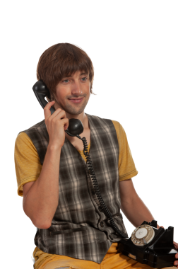 Genç bir adam klasik bir döner telefon kullanarak keyifli bir sohbetten hoşlanır..