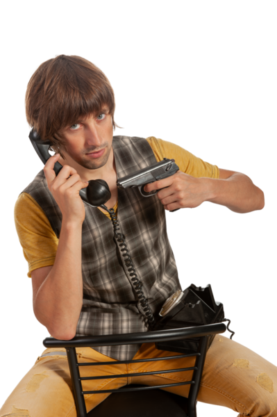 Genç bir adam bir elinde telefon, diğer elinde bir silah, bir sandalyede oturuyor..