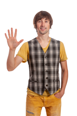 Neşeli genç bir adam dostça bir gülümseme ile el sallıyor, ekose bir yelek ve sıradan bir tişört giyiyor..