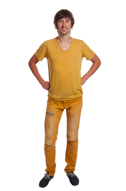 Canlı bir genç adam kendine güvenerek ayakta duruyor, şık sarı kıyafetini gösteriyor ve gülümsüyor..