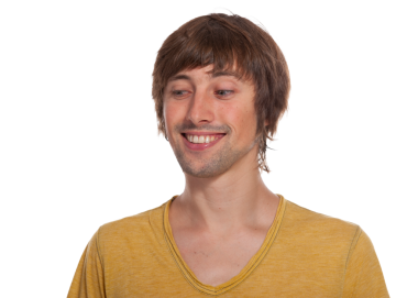 Genç adam, günlük sarı bir gömlek giyerken geniş bir gülümsemeyle neşe ifade eder..