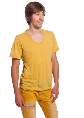 Parlak sarı gömlek ve pantolon giymiş neşeli bir adam kendine güvenerek duruyor, gülümsüyor..