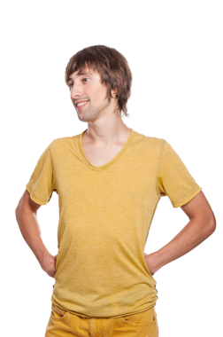 Neşeli genç bir adam elleri kalçasında duruyor, pozitif enerji ve kendine güven saçıyor..