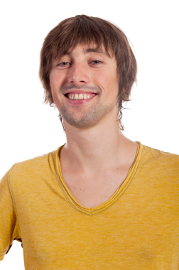 Neşeli bir gülümsemesi olan genç bir adam gelişigüzel poz verir, sıcaklığı ve güveni yayar..