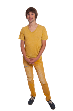 Genç bir adam rahat bir pozla duruyor, açık sarı bir gömlek ve kot pantolon giyiyor..