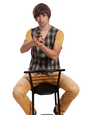 Genç bir adam sandalyede otururken kendinden emin bir şekilde oyuncak bir silah tutuyor, eğlenceli bir enerji sergiliyor..