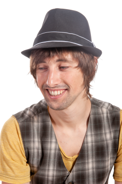 Siyah şapkalı neşeli bir şahıs samimi bir şekilde gülümsüyor..