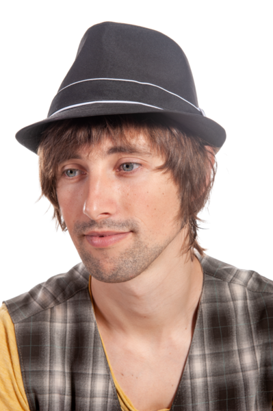 Fötr şapkalı bir insan parlak stüdyo ışıklarında düşünceli bir şekilde bakar..