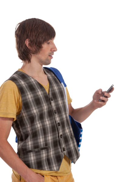 Ekose yelekli genç bir adam ayakta dikilirken dikkatle akıllı telefonuna odaklanır..