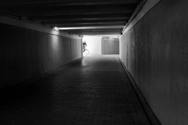 Tek başına bir bisikletçi loş bir tünele girer ve akşam ışığı onu sondan çağırır..