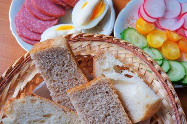 Lezzetli kahvaltı dilimleri, haşlanmış yumurtalar ve canlı sebze kenarları içerir..