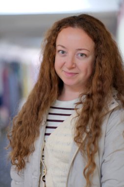 Parlak kıvırcık saçlı kadın, evin içinde gündelik bir anın tadını çıkarırken sıcaklık saçıyor.