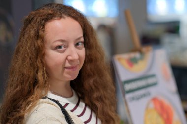 Bir kadın zarif bir şekilde bir kafe masasında oturur ve evde huzurlu bir anın tadını çıkarır.