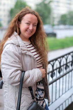 Canlı bir şehir ortamında, neşeli bir kadın kendine güvenerek yürüyor, gününün tadını çıkarıyor..