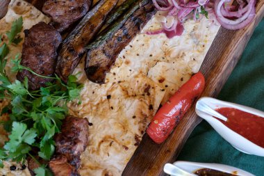 Lezzetli bir ziyafet, ızgara et, sebze ve tadını çıkarmaya hazır taze otlar..