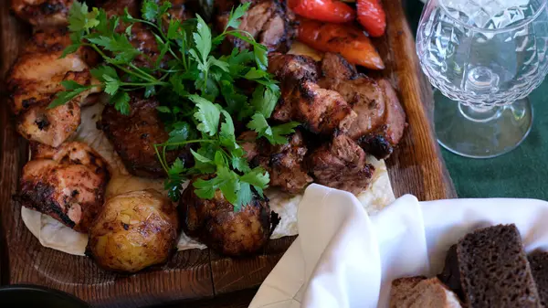 Sıcak bir toplantıda canlı bir tabak ızgara et, biber ve otlar bekliyor..