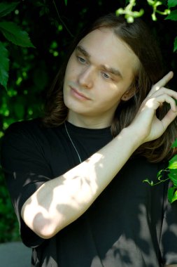 Düşünceli bir birey, canlı yeşilliklerle nazik bir şekilde etkileşime girer..