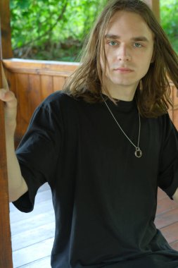 Düşünceli bir genç adam huzurlu bir ahşap yapıda huzurlu bir varlık sunar..