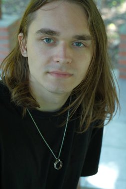 Sakin bir genç adam, dışarıda, yumuşak güneş ışığı altında huzurlu bir anın tadını çıkarır..