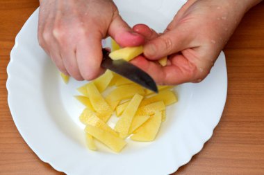 Eller taze patatesleri ustalıkla soyar, evde lezzetli bir yemeğe hazırlanır..