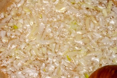 Sıcak yağda ince doğranmış soğan kabarcığı, mutfağa lezzetli bir koku yayıyor..