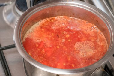 Taze domatesler tencerede kaynıyor, lezzet ve sıcaklıkla kaynıyor fırında..