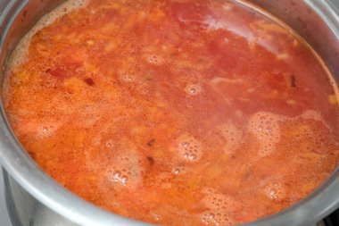 Baharat ve sebzelerle dolu kalın et suyu sıcakta yavaşça pişirir ve havayı doldurur..